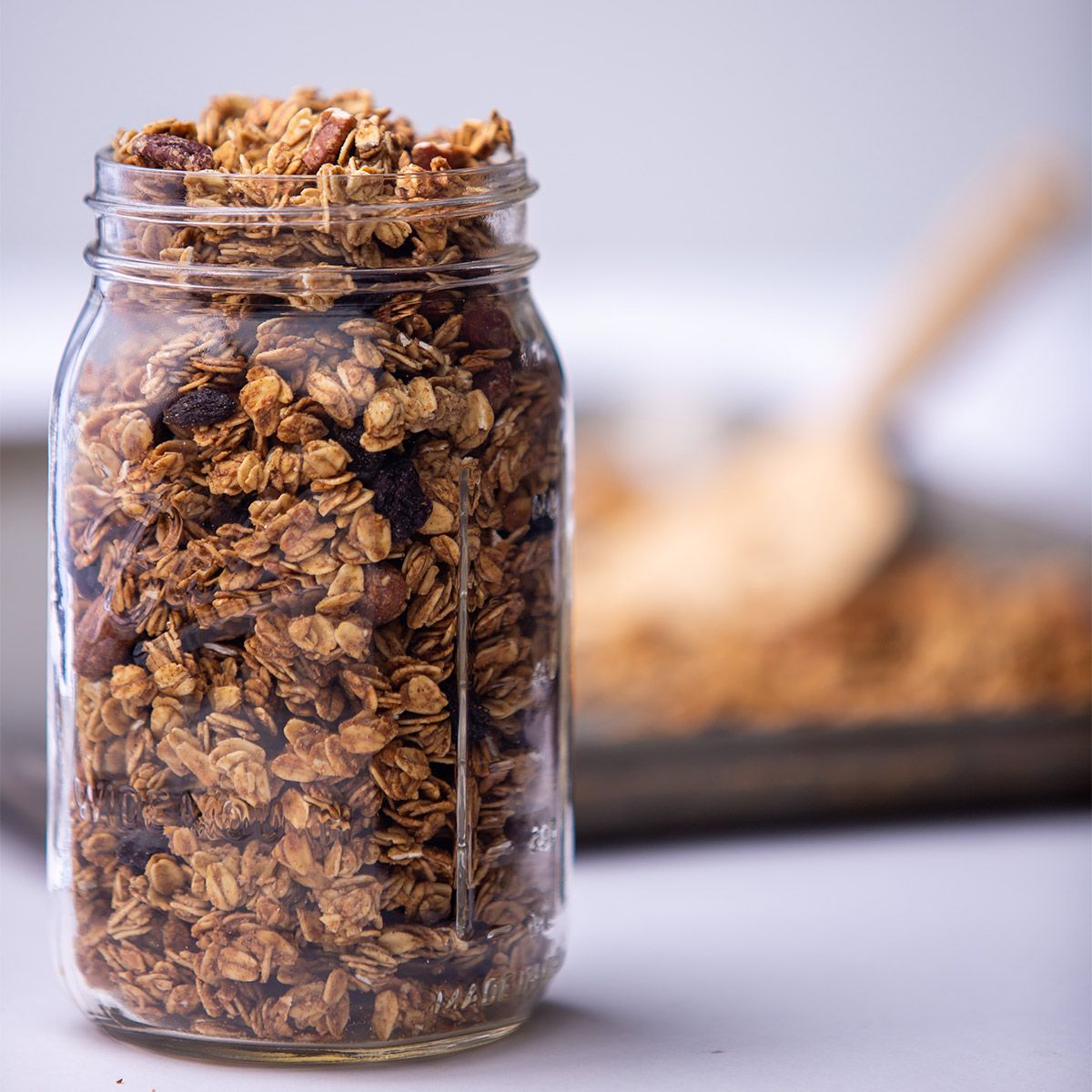 A jar of bulk granola sitting on a countertop