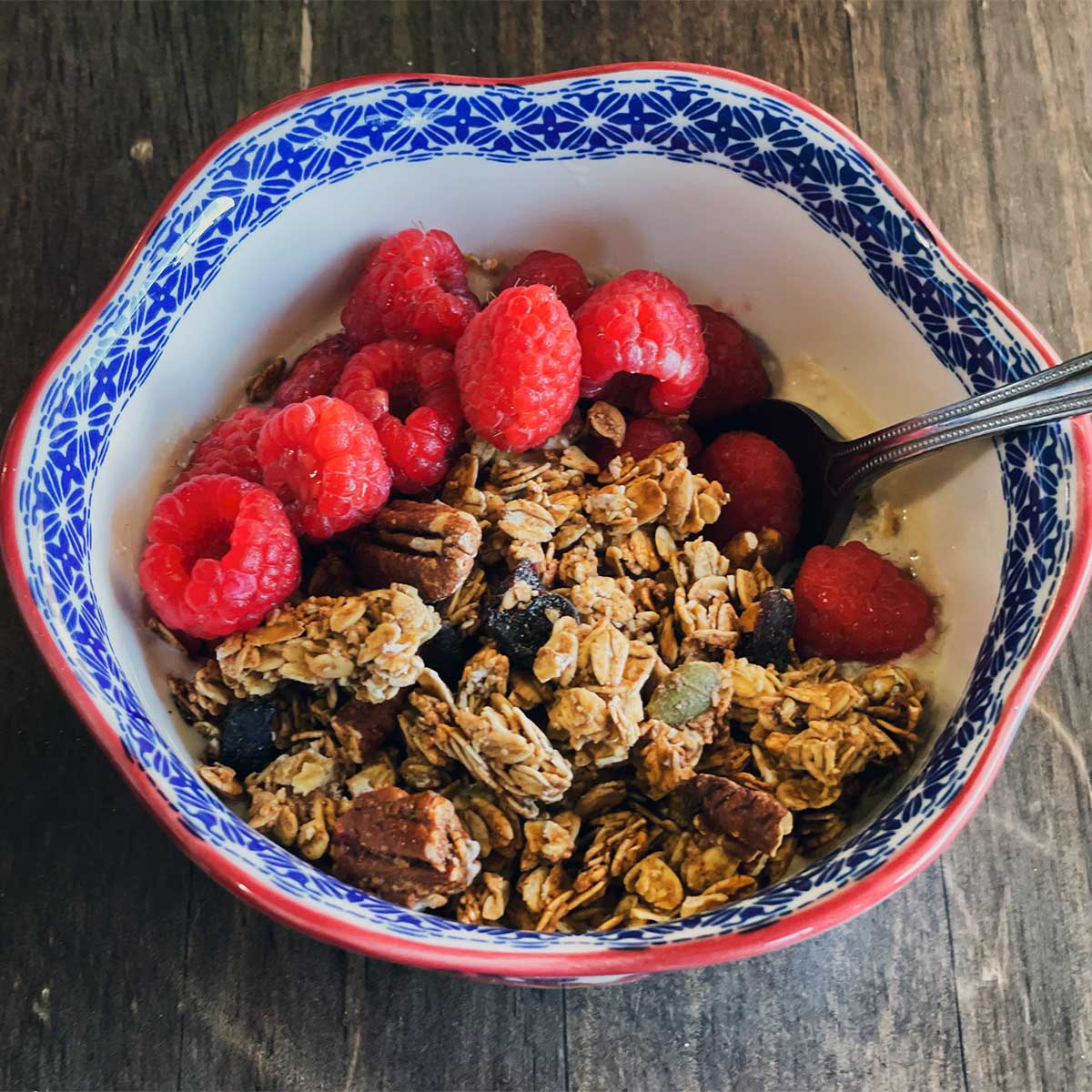 a protein granola bowl with cottage cheese, granola, and fresh rasberries.