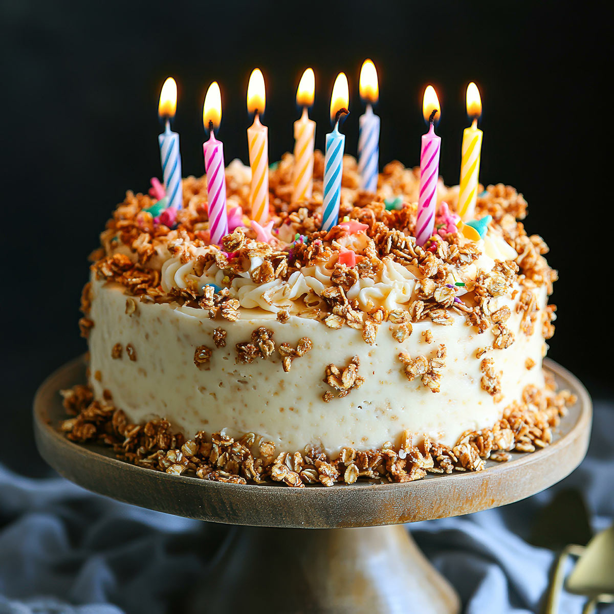 Birthday cake topped with granola and lit candles for a little red wagon 20 year anniversary blog