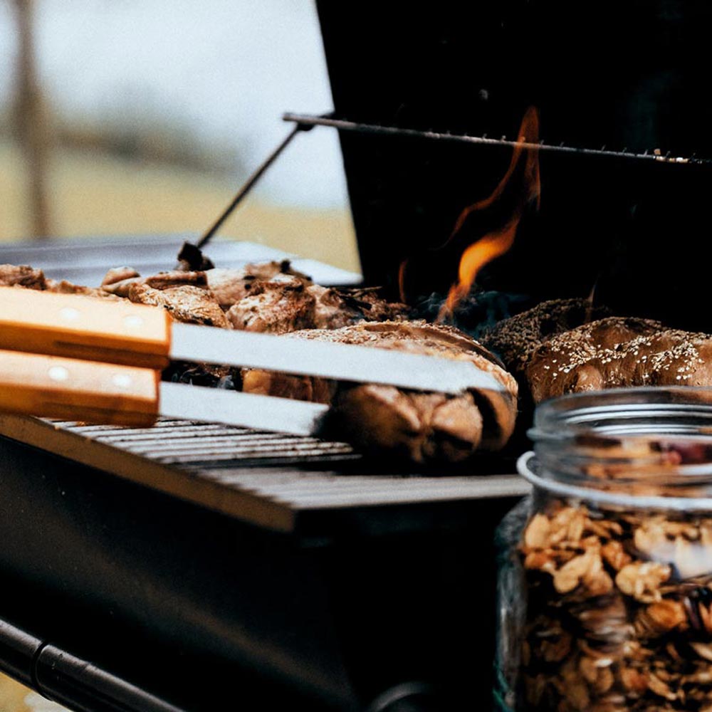 tongs flipping meat on the grill for a backyard bbq